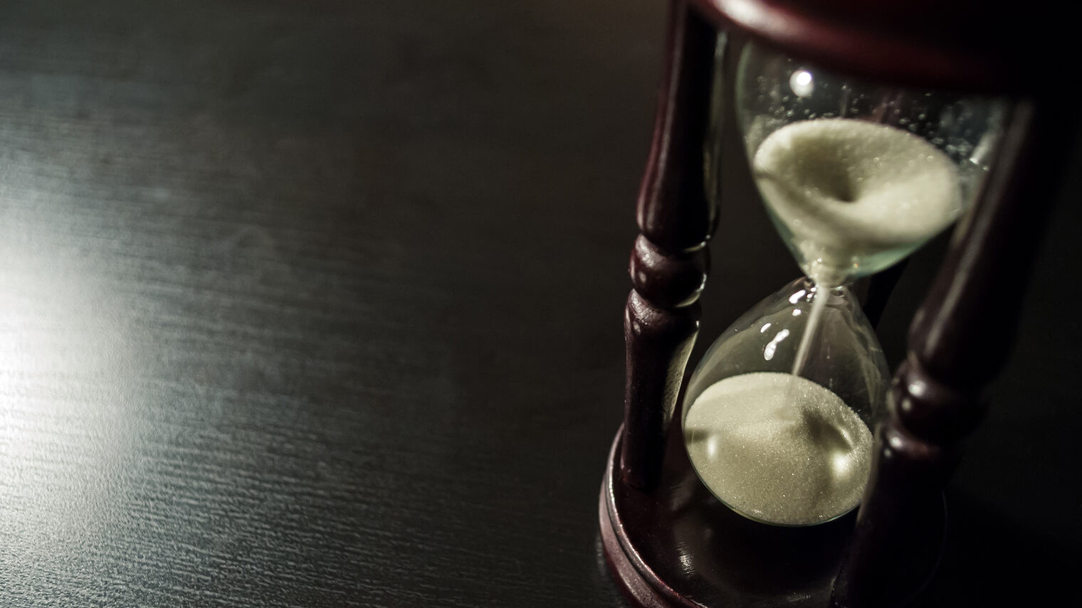 old hourglass stand on a dark wooden table Schlagwort(e): age, aging, ancient, antique, arena, background, black, brown, business, close-up, closeup, color, concept, countdown, dark, deadline, desk, glass, hour, hourglass, idea, instrument, instrumento, minutes, old, old-fashioned, past, process, reflection, retro, sands, seconds, time, timepiece, timer, urgency, urgent, vintage, wood, wooden