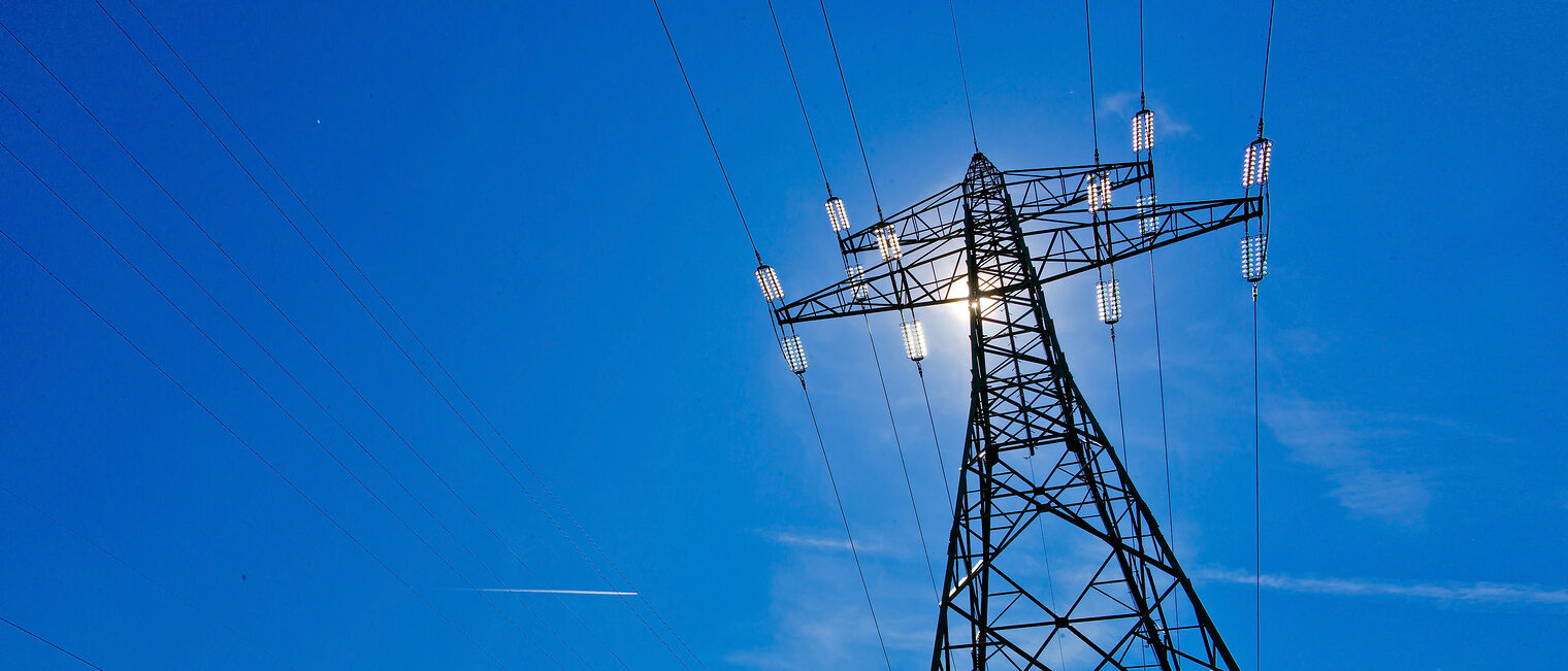 Ein Strommast einer Hochspannungsleitung mit Sonne vor blauem Himmel Schlagwort(e): Stromleitung, Strom, Strommast, Hochspannungsleitung, Energie, Stromerzeugung, Erzeugung, Sonnenenergie, Solarstrom, Himmel, blauer, blauem, Sonne, Solarenergie, Alternativenergie, alternative, Produktion, Stromproduktion, Strommasten, Hochspannungsmasten, Leitung, Hochspannungsmast, Mast, Freileitung, Kabel, Stromkabel, Masten, Elektroversorgung, Überlandleitung, Versorgung, pylon, Hochspannung, Atomkraft, Fernübertragung, Übertragung, Fernleitung, Stromnetz, Infrastruktur, Kraftwerk, Elektrosmog, Wirtschaft, Stromverbrauch, Strombedarf, Stromkosten, Elektrizität, Stromversorgung, Strompreis, elektrische