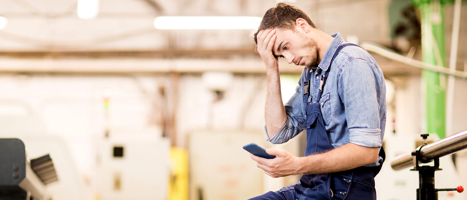 Besorgter Handwerker mit Smartphone. Bild: pressmaster / stock.adobe.com