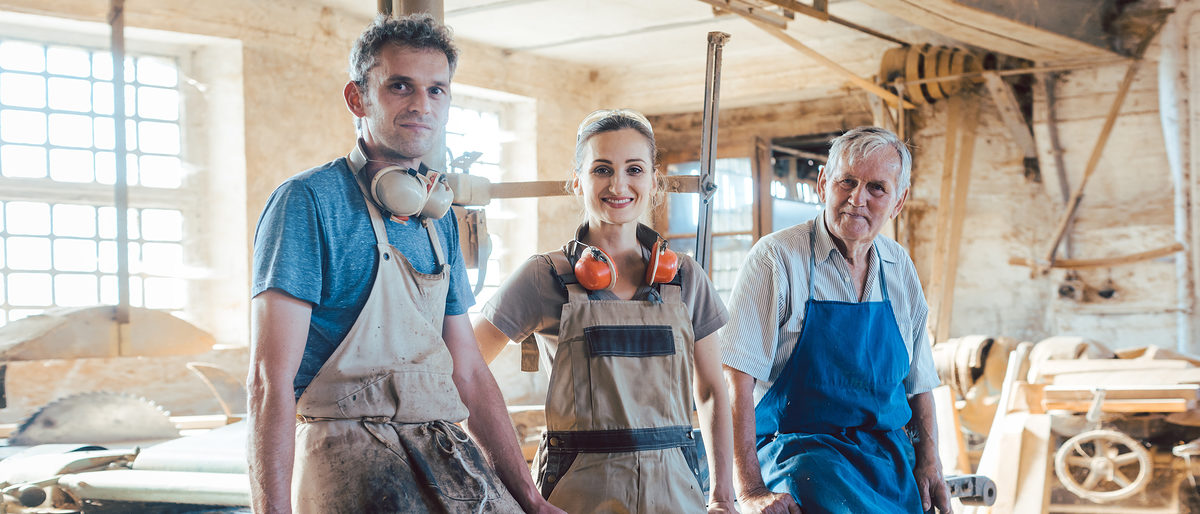 Carpenter family business with generations in the workshop having a break Schlagwort(e): Carpenter, Family business, generations, young, continuity, generation change, succession, cabinet maker, joiner, man, woman, team, teamwork, senior, experienced, old, Master, apprentice, colleagues, together, Carpentry, workshop, wood, joinery, carpenters workshop, woodworking, Occupation, work, working, job, craftsman, craft, Proud, pride, Looking at camera, Vintage, traditional, old school, People, person, Caucasian, German, Germany, small business