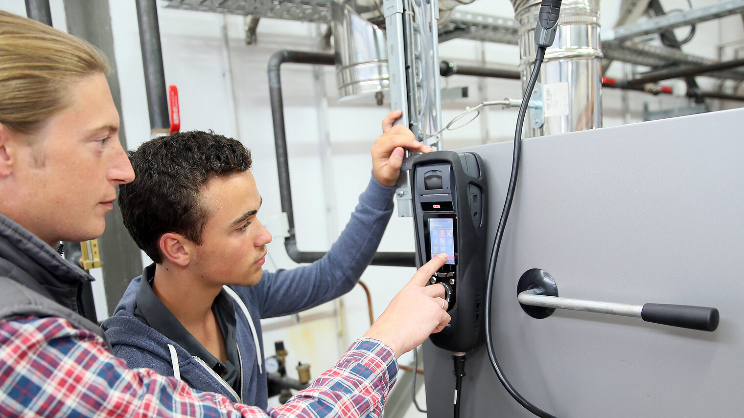 Young man in professional training measuring heat pump temperature Schlagwort(e): electricity, heat pump, intensity, temperature, equipment, measure, measuring, measurement, control, engineer, renewable energy, environmental, training, young man, trainee, apprenticeship, apprentice, student, professional, occupation, adult, trainer, teacher, machinery, school, craftsman, craftsmanship, technician, worker, electronic, plumber, electricity, heat pump, intensity, temperature, equipment, measure, measuring, measurement, control, engineer, renewable energy, environmental, training, young man, trainee, apprenticeship, apprentice, student, professional, occupation, adult, trainer, teacher, machinery, school, craftsman, craftsmanship, technician, worker, electronic, plumber