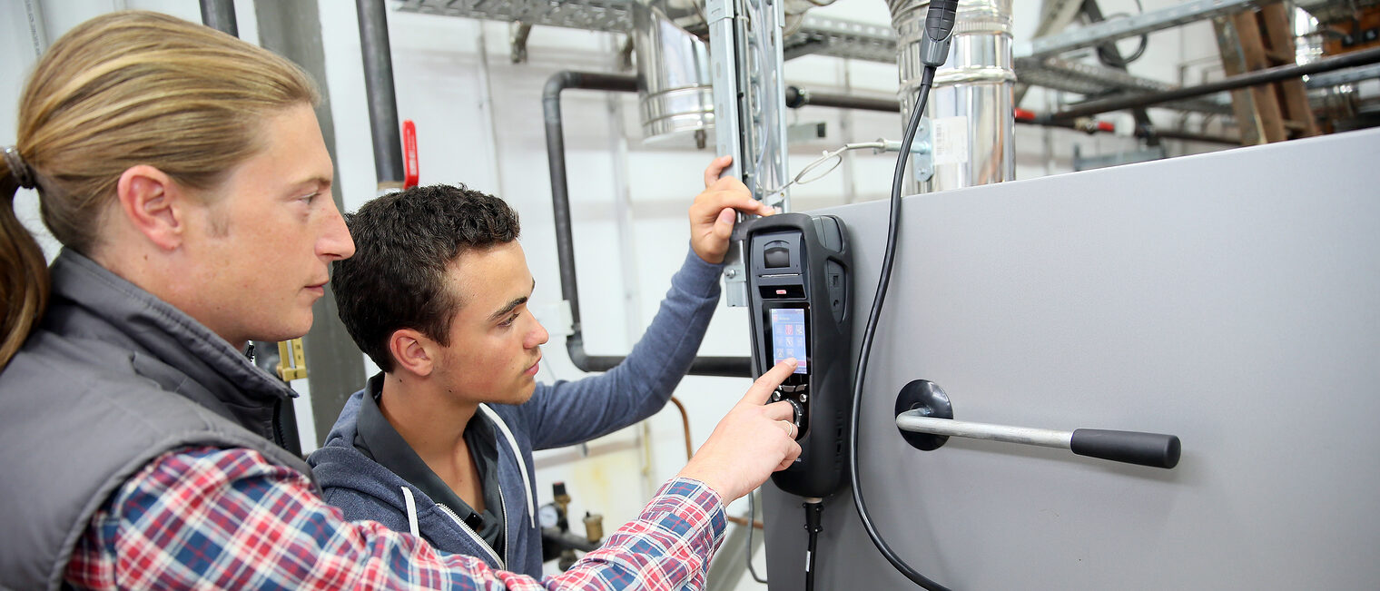 Young man in professional training measuring heat pump temperature Schlagwort(e): electricity, heat pump, intensity, temperature, equipment, measure, measuring, measurement, control, engineer, renewable energy, environmental, training, young man, trainee, apprenticeship, apprentice, student, professional, occupation, adult, trainer, teacher, machinery, school, craftsman, craftsmanship, technician, worker, electronic, plumber, electricity, heat pump, intensity, temperature, equipment, measure, measuring, measurement, control, engineer, renewable energy, environmental, training, young man, trainee, apprenticeship, apprentice, student, professional, occupation, adult, trainer, teacher, machinery, school, craftsman, craftsmanship, technician, worker, electronic, plumber