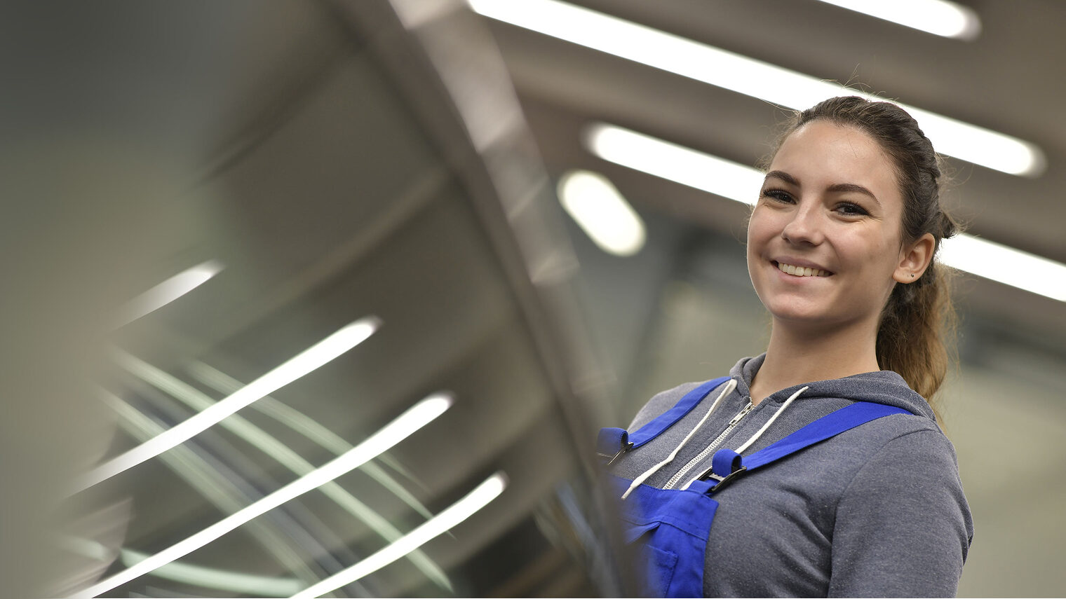 Junge Frau in der Kfz-Werkstatt. Bild: goodluz / stock.adobe.com