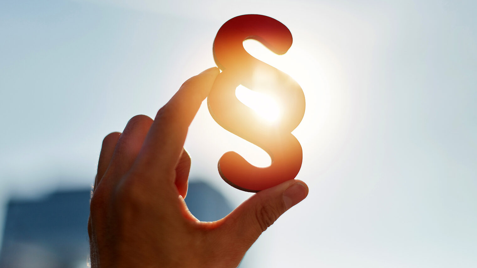 Hand hält Paragraphen Symbol in Sonne, Rechtsformen. Bild: Robert Kneschke / stock.adobe.com