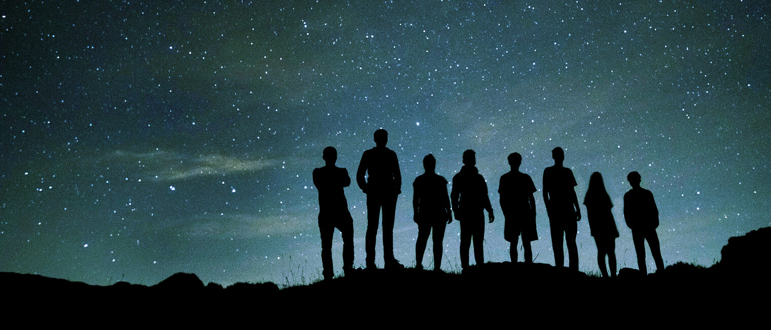 Menschen vor Sternenhimmel bei Nacht. Bild: JK / stock.adobe.com