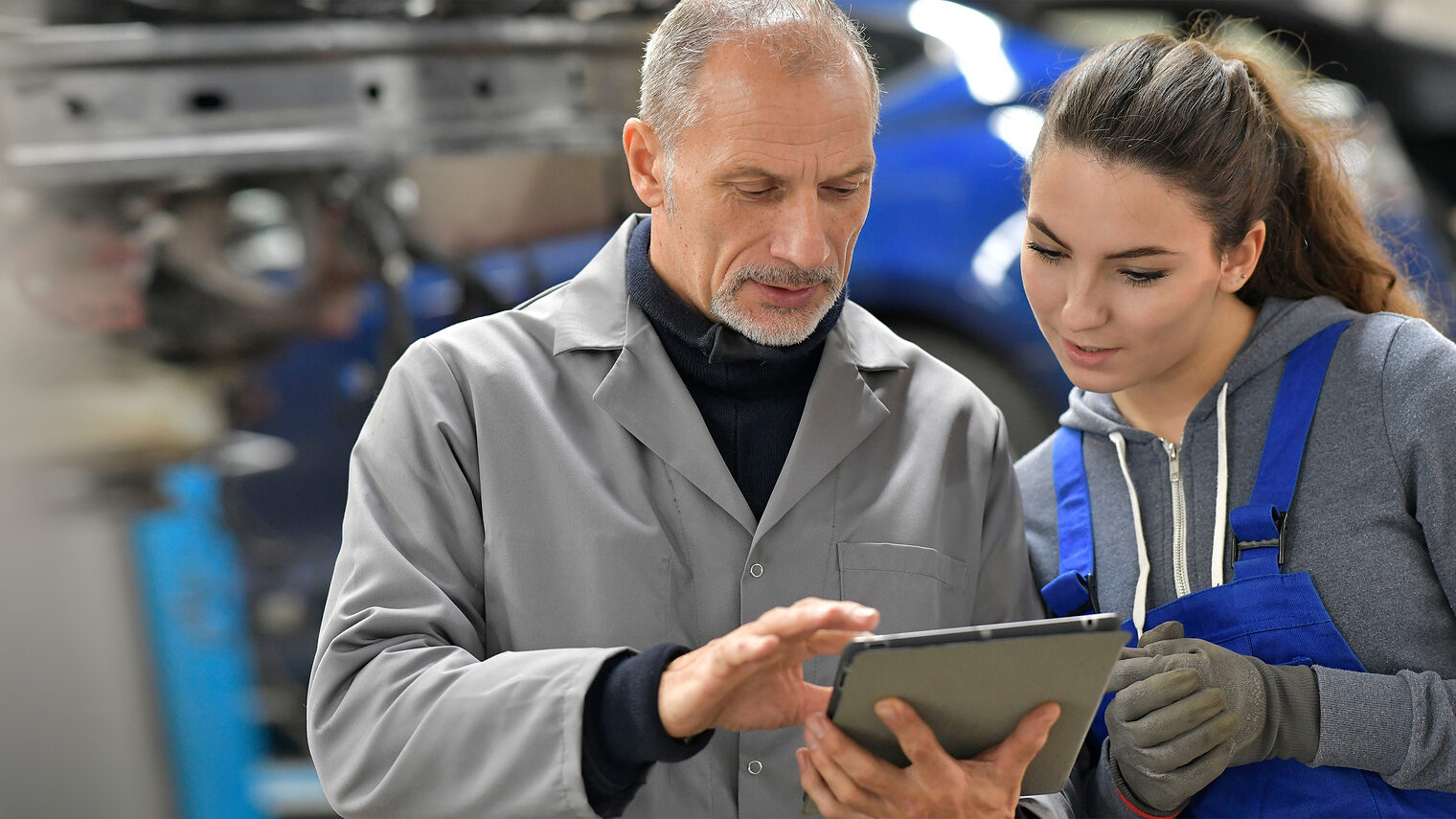 Auszubildende mit Lehrmeister in der Kfz-Werkstatt. Bild: stock.adobe.com / goodluz
