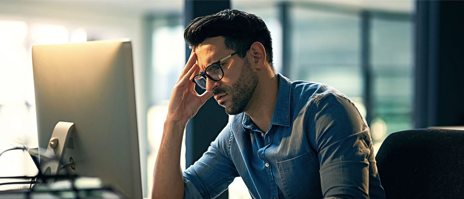 Genervter Handwerker vor dem Rechner im Büro. Bild: peopleimages / stock.adobe.com