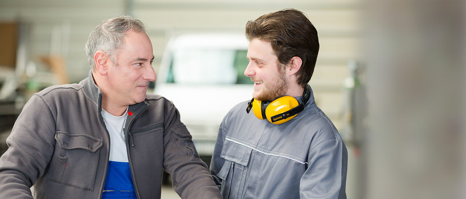 Seniorunternehmer und jüngerer Handwerker im Gespräch. Bild: auremar / stock.adobe.com