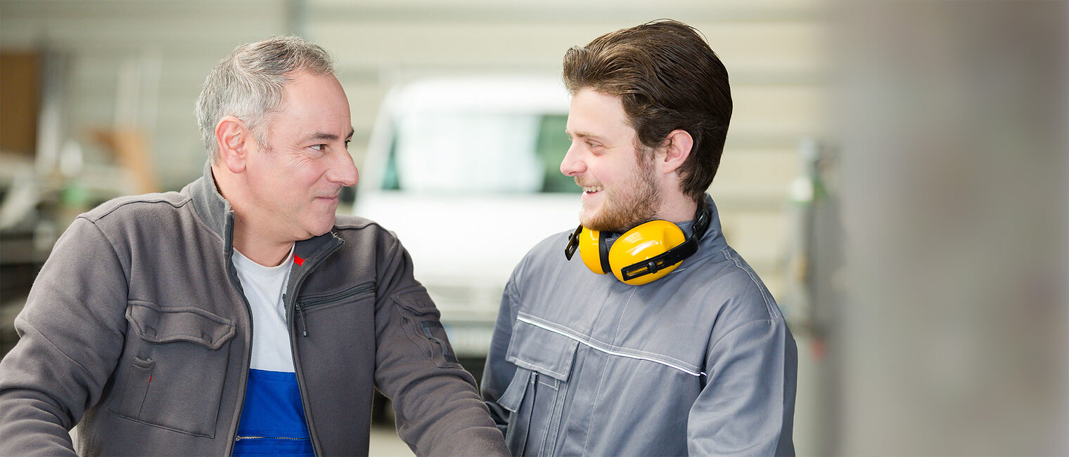 Seniorunternehmer und jüngerer Handwerker im Gespräch. Bild: auremar / stock.adobe.com