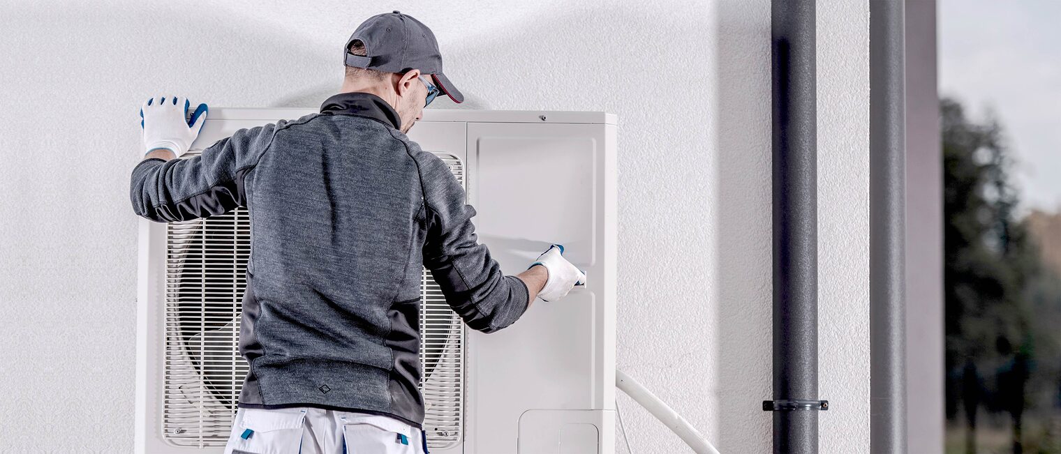 Fachmann arbeitet an einer Wärmepumpe. Bild: stock.adobe.com / Tomasz Zajda