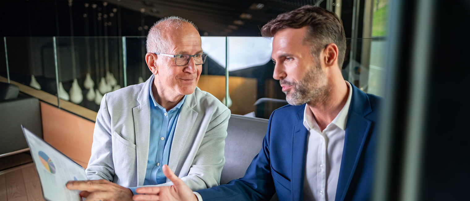 Gespräch im Büro zwischen Senio-Unternehmer und jungem Entrepreneur. Bild: stock.adobe.com / Leszek Glasner