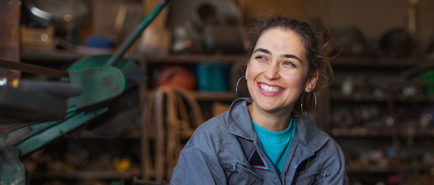 Junge Frau in einer Werkstatt. Bild: stock.adobe.com / aerogondo