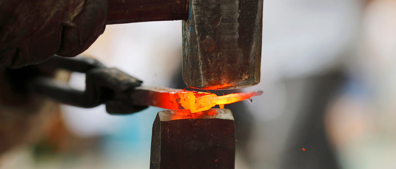 Schmieden eines glühenden Metallteils. Bild: stock.adobe.com / lukasok