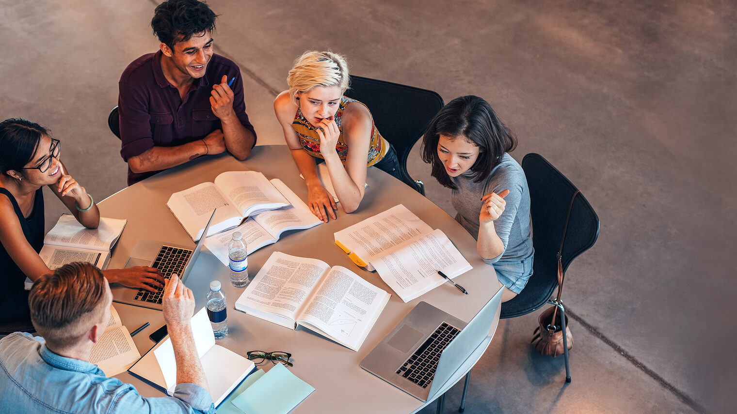 Eine Gruppe von Studenten arbeitet im Team an einem Tisch. Weiterbildung. Bild: Jacob Lund / stock.adobe.com