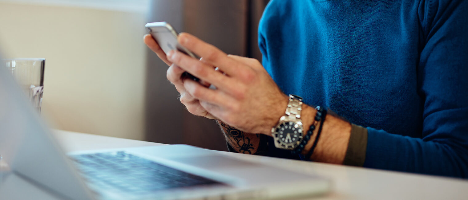 Detailaufnahme einer Hand mit einem Smartphone. Bild: stock.adobe.com / chika milan 