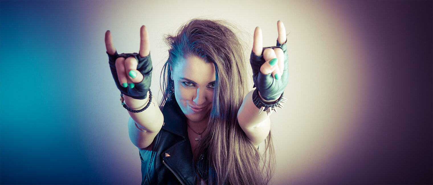 Heavy-Metal-Girl zeigt die "Pommesgabel". Bild: stock.adobe.de / Dark Okami