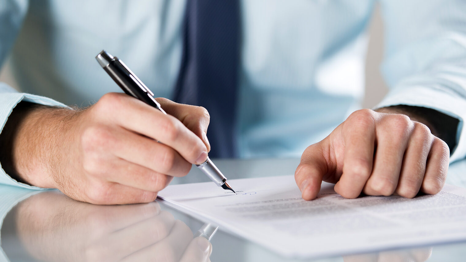 Mann unterschreibt Vertrag, Stift. Bild: Halfpoint /stock.adobe.com