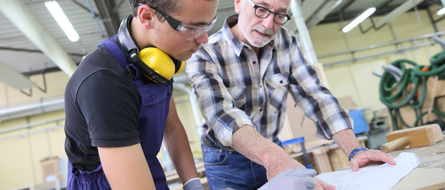 Tischlerausbildung: Lehrling mit Meister in der Werkstatt. Bild. fotolia.com - goodluz