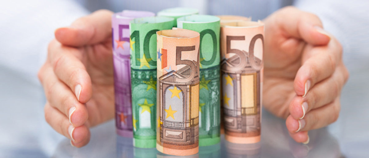 Close-up Of Hand Protecting Rolled Up Euro Banknote Schlagwort(e): money, paper, people, insurance, success, finance, glass, green,