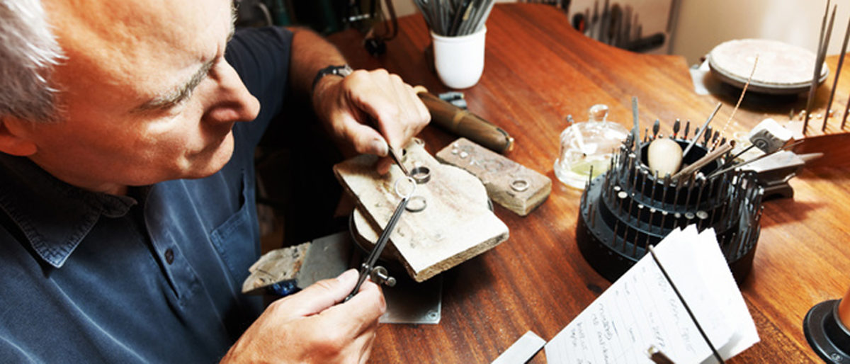 Senior man working at shaping a ring Schlagwort(e): adult, caucasian, chisel, close, closeup, face, goldsmith, grey, hair, hammer, hand, hands, holding, industry, jewelry, job, light, look, looking, male, man, mature, men, metal, note, one, paper, people, person, professional, ring, senior, serious, sitting, table, tool, trade, tradesman, work, working