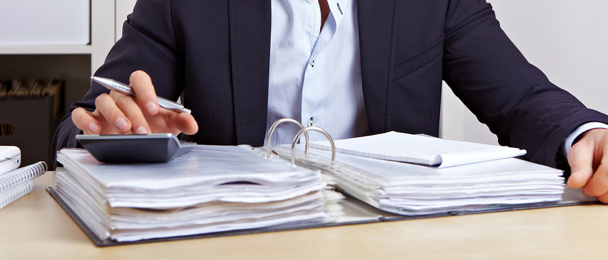 Mitarbeiter vom Finanzamt macht eine Betriebsprüfung mit Taschenrechner im Büro Schlagwort(e): Mann, Taschenrechner, rechnen, Finanzierung, Business, Büro, Buchhaltung, Berater, Fachberater, Akte, Aktenordner, Steuerberater, Finanzen, Kalkulation, kalkulieren, Berechnung, Auswertung, Betriebsprüfung, Finanzamt, Steuerprüfung, Prüfer, Buchhalter, Geld, Aufgabe, Student, Geschäftsmann, Schreibtisch, Arbeitsplatz, Erfolg, freudig, Tisch, Job, arbeiten, Manager, Azubi, lernen, Kaufmann, attraktiv, Karriere, Verwaltung, glücklich, Bürokratie, Angestellter, tippen, Arbeit, Beruf, sitzen, Mensch, Person, Europäer