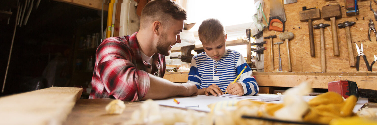 family, carpentry, woodwork and people concept - happy father and little son with blueprint at workshop Schlagwort(e): family, son, father, workshop, blueprint, notebook, diy, happy, pencil, writing, smiling, man, boy, carpentry, carpenter, woodwork, wood, workman, people, person, manual, young, indoors, male, working, home, work, craft, lumber, workbench, timber, woodworker, joiner, craftsman, handyman, kid, child, teaching, learning, job, building, parent, parenting, fatherhood, little, together, plan, layout, drawing, chippy