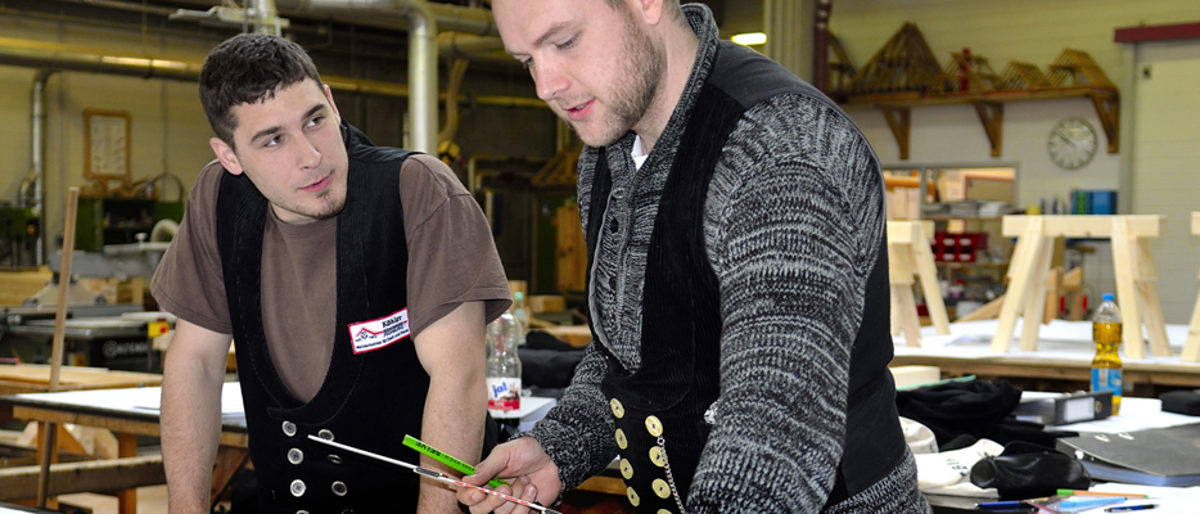 Im Bildungs- und Technologiezentrum zeigt sich, dass ältere Lehrlinge wie der "studierte Zimmermann" Daniel Fechtel (r.) einen positiven auf ihre Klasse haben. Hier vermisst er gemeinsam mit Jakob Steglich Teile für einen Holzbock.