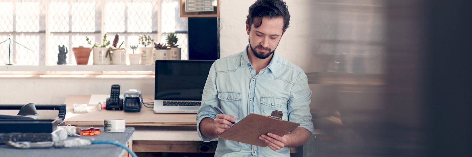 Handwerker mit Clipboard im Büro bzw. in der Werkstatt. Bild: mavoimages / fotolia.com