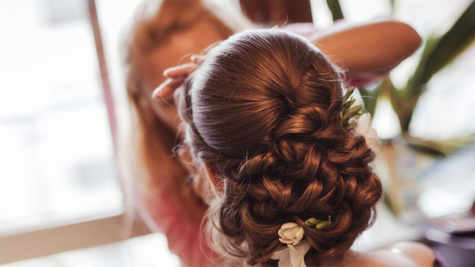 Friseurin macht eine Hochsteckfrisur. Bild: Milissenta / fotolia.com