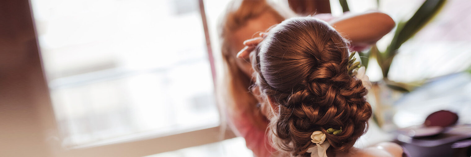 Friseurin macht eine Hochsteckfrisur. Bild: Milissenta / fotolia.com