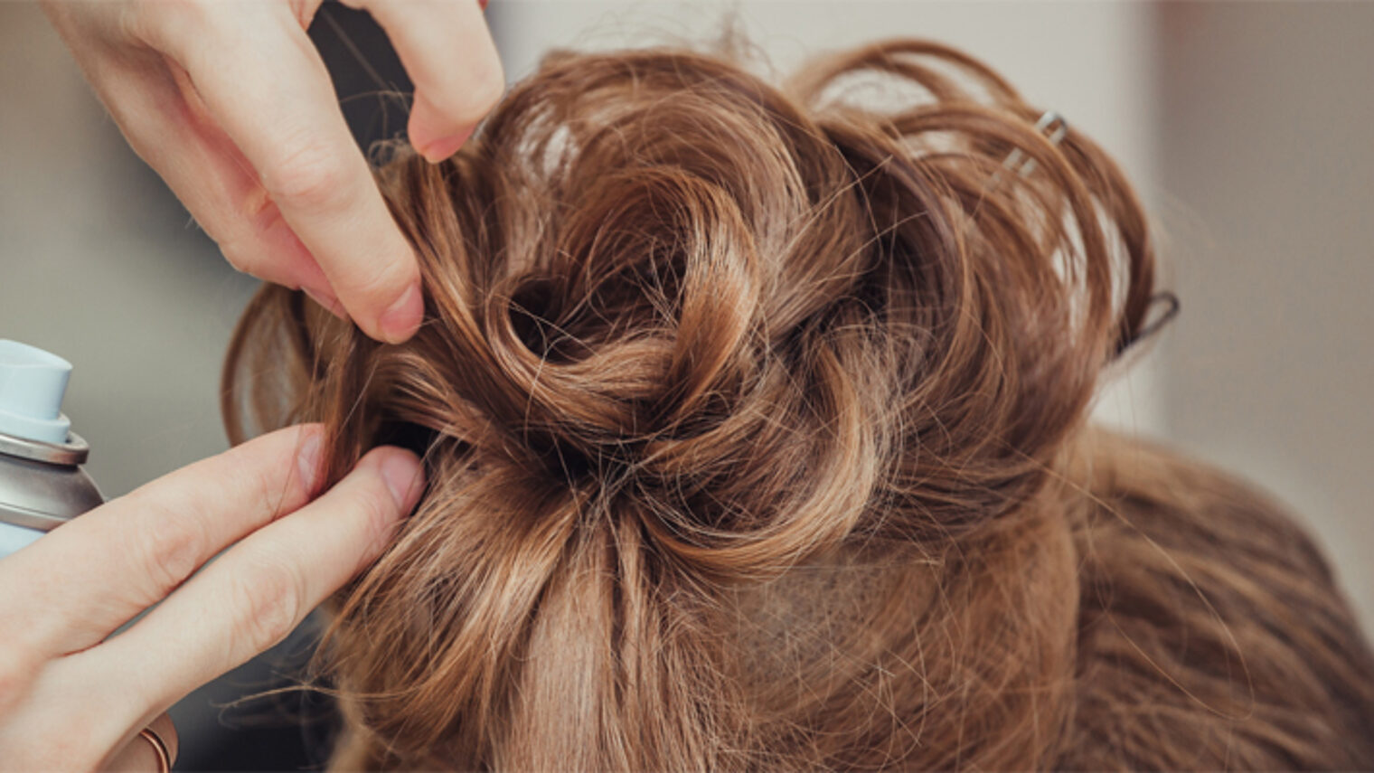 Friseurin macht eine Hochsteckfrisur. Bild: EdNurg / stock.adobe.com