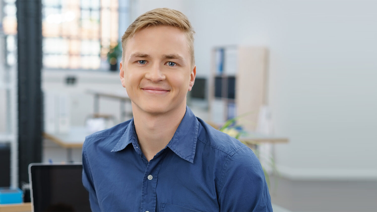 Lächelnder junger Handwerker im Büro. Bild: contrastwerkstatt / stock.adobe.com