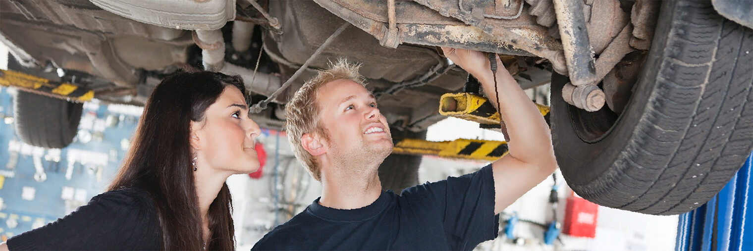 Young mechanic and woman looking at machine of car in auto repair shop Schlagwort(e): happy, smile, work, customer, woman, female, mechanic, service, adult, automobile, business, caucasian, employee, engineering, expertise, garage, horizontal, industry, job, lifestyle, maintenance, male, man, mechanical, occupation, people, profession, professional, repair, store, technician, workshop, car, vehicle, shop, talk, agreement, order, problem, show, explain, underbody, lift, under, tire, break, suspension, client, looking, two