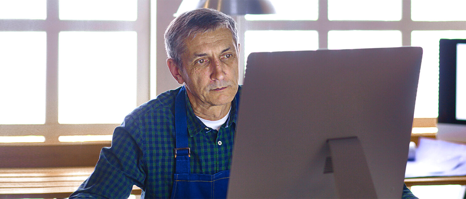 Älterer Handwerker / Meister im Büro am Computer. Bild: lenetsnikolai / stock.adobe.com