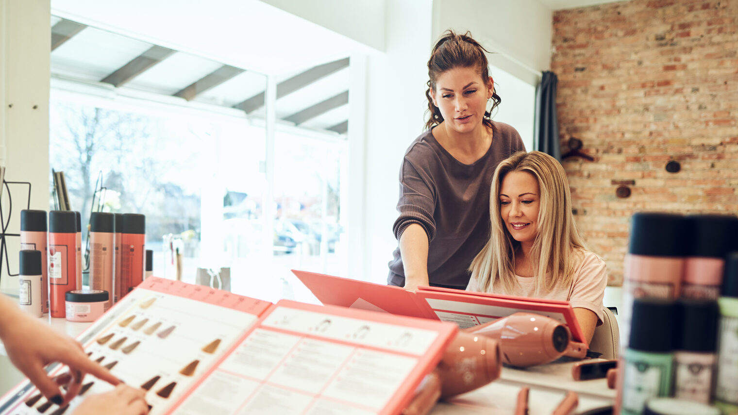 Friseursalon mit Kundenberatungssituation. Bild: Flamingo Images / stock.adobe.com