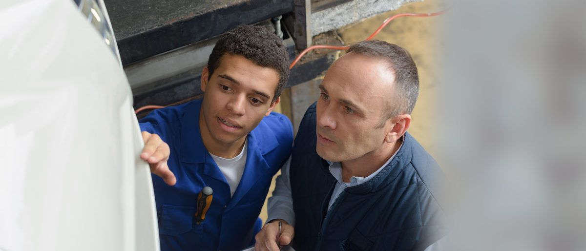 Meister und Praktikant mit Migrationshintergrund in der Werkstatt. Bild: auremar / stock.adobe.com