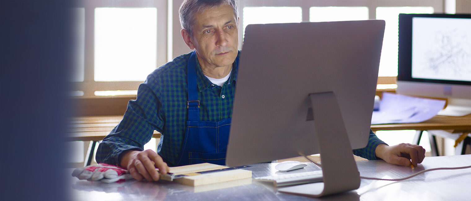 Älterer Handwerker / Meister im Büro am Computer. Bild: lenetsnikolai / stock.adobe.com